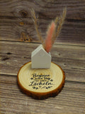 kleine Förmchen mit Trockenblumen und Holzscheibe oder Holzhintergrund